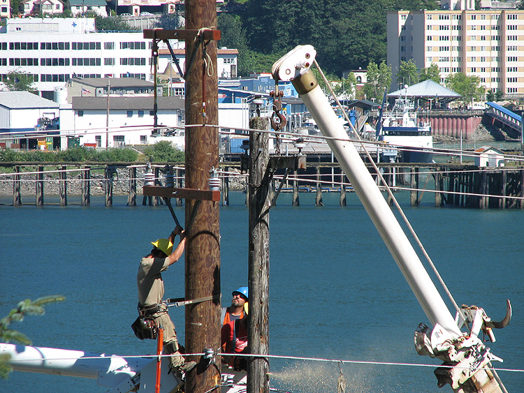 Removing the upper part of the 1980 utility pole along Douglas Highway.
